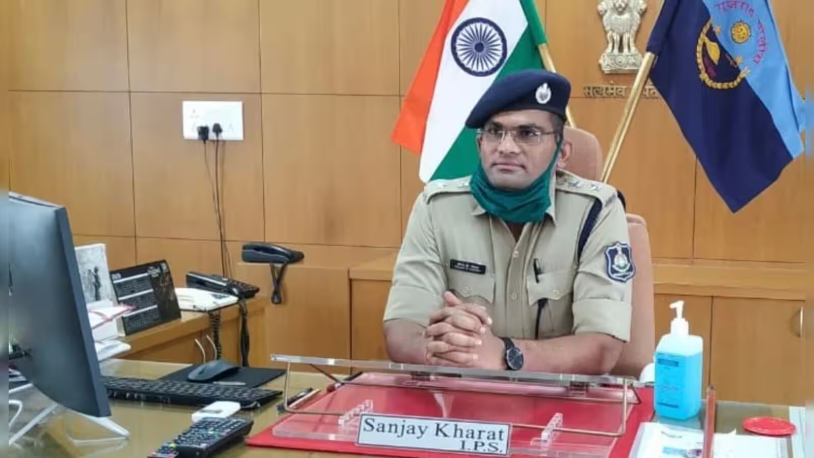Sanjay Kharat seated at the Superintendent of Police desk, with the national flag and departmental standards behind him and the desk nameplate reading Sanjay Kharat, I.P.S.